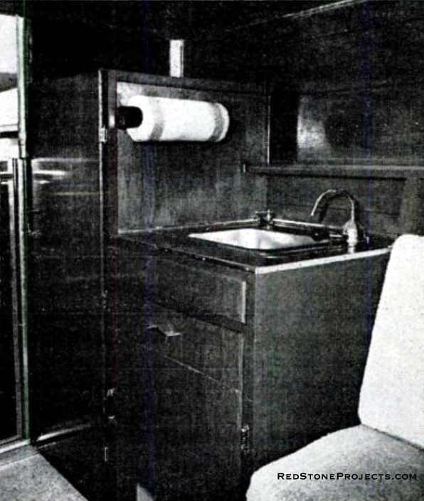 Sink and water tank share the section in front, with storage to spare. Clothes hang neatly in wardrobe.